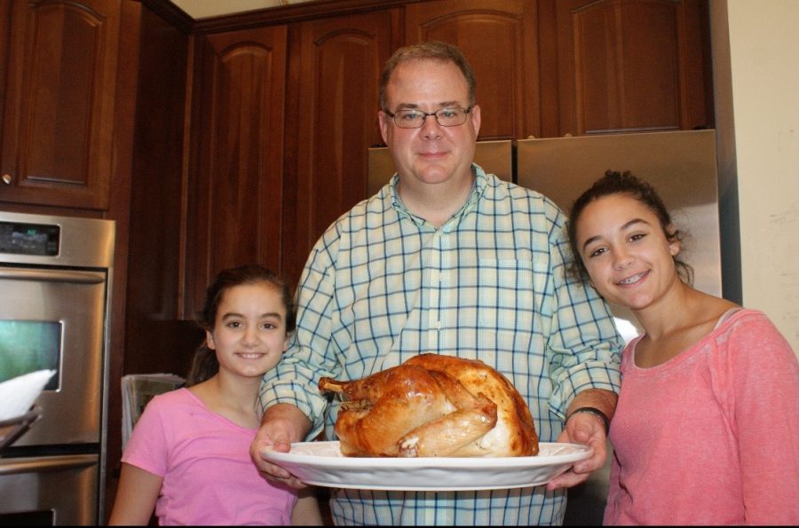 Jessica Clover '22 stands proudly with her father and sister Catherine Clover '19 after making their Thanksgiving turkey.