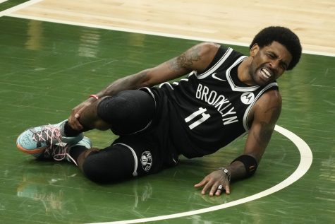 Brooklyn Nets Kyrie Irving holds his leg after being injured during the first half of Game 4 of the NBA Eastern Conference basketball semifinals game against the Milwaukee Bucks Sunday, June 13, 2021, in Milwaukee. (Los Angeles Times)