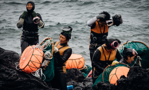 The Haenyeo Divers get ready for a dangerous and tricky dive. They carry all of their equipment with them.